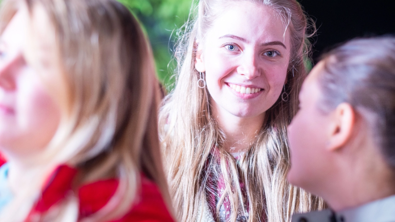 Ein junge Frau lächt in die Kamera