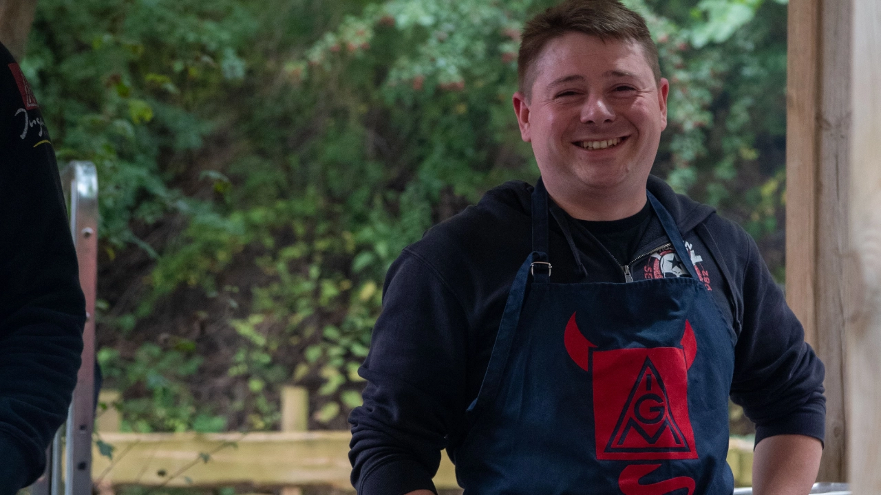 Ein Mann it Grillschürze am Grill