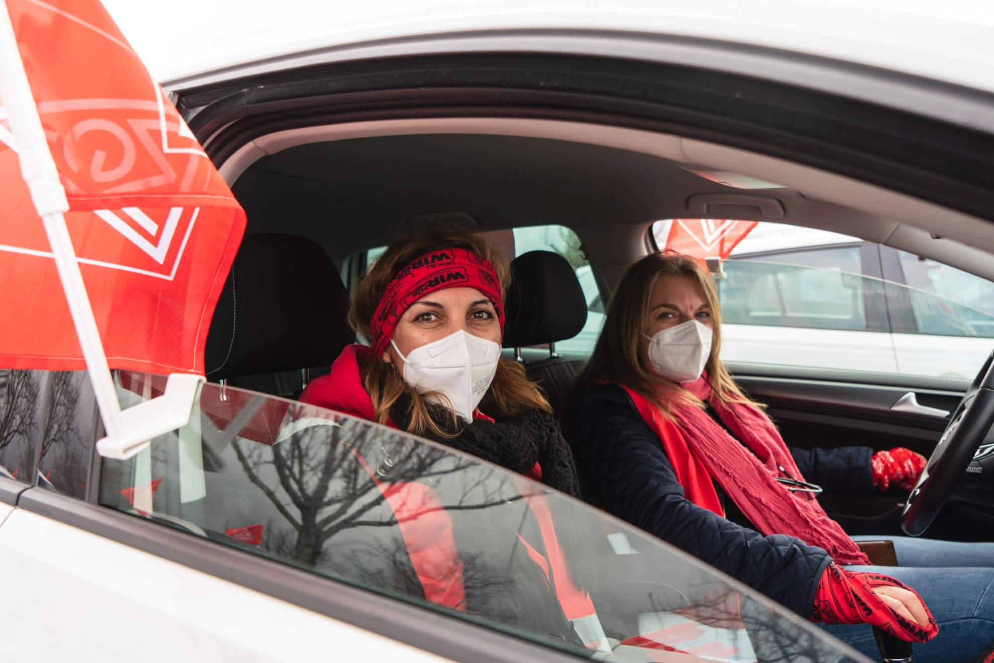 Zwei Frauen sitzen im Auto und haben IG Metall Klamotten an