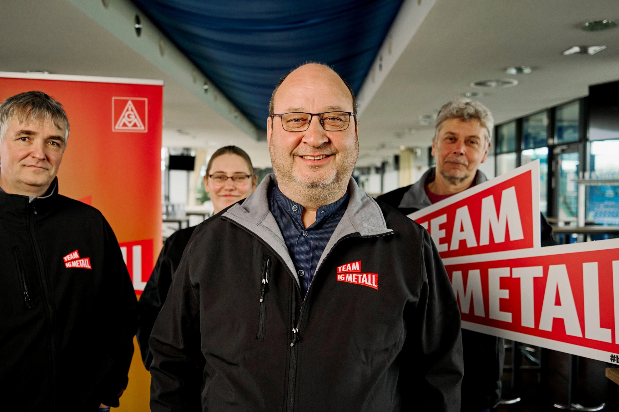 Eine Gruppe Menschen repräsentiert das Team, das für den Betriebsrat kandidiert, gemischt aus einer Frau und 3 Männern 
