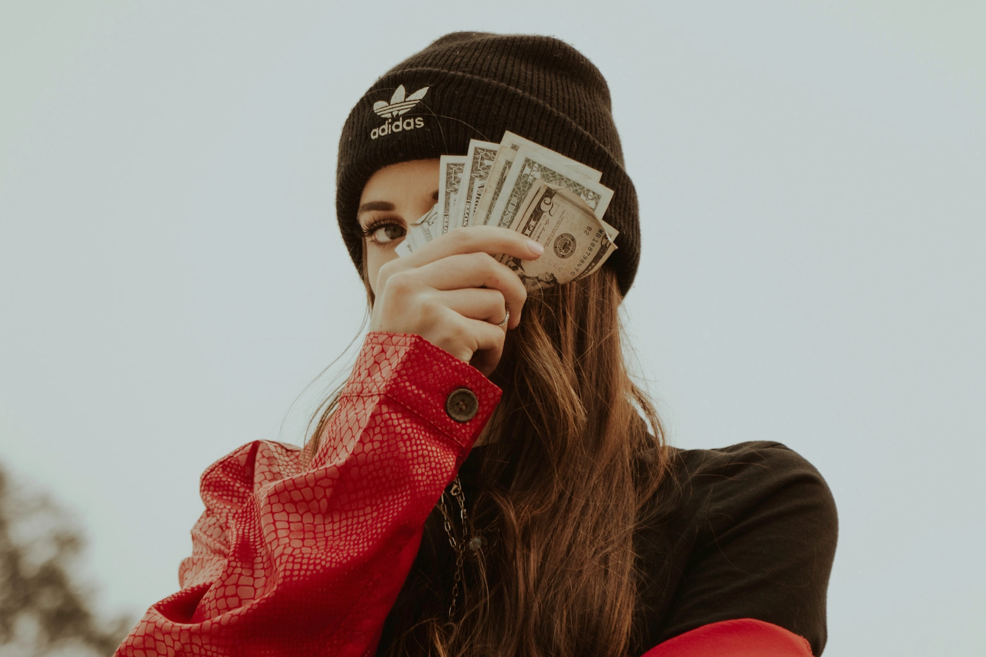 Junge Frau hält ein paar Geldscheine hoch