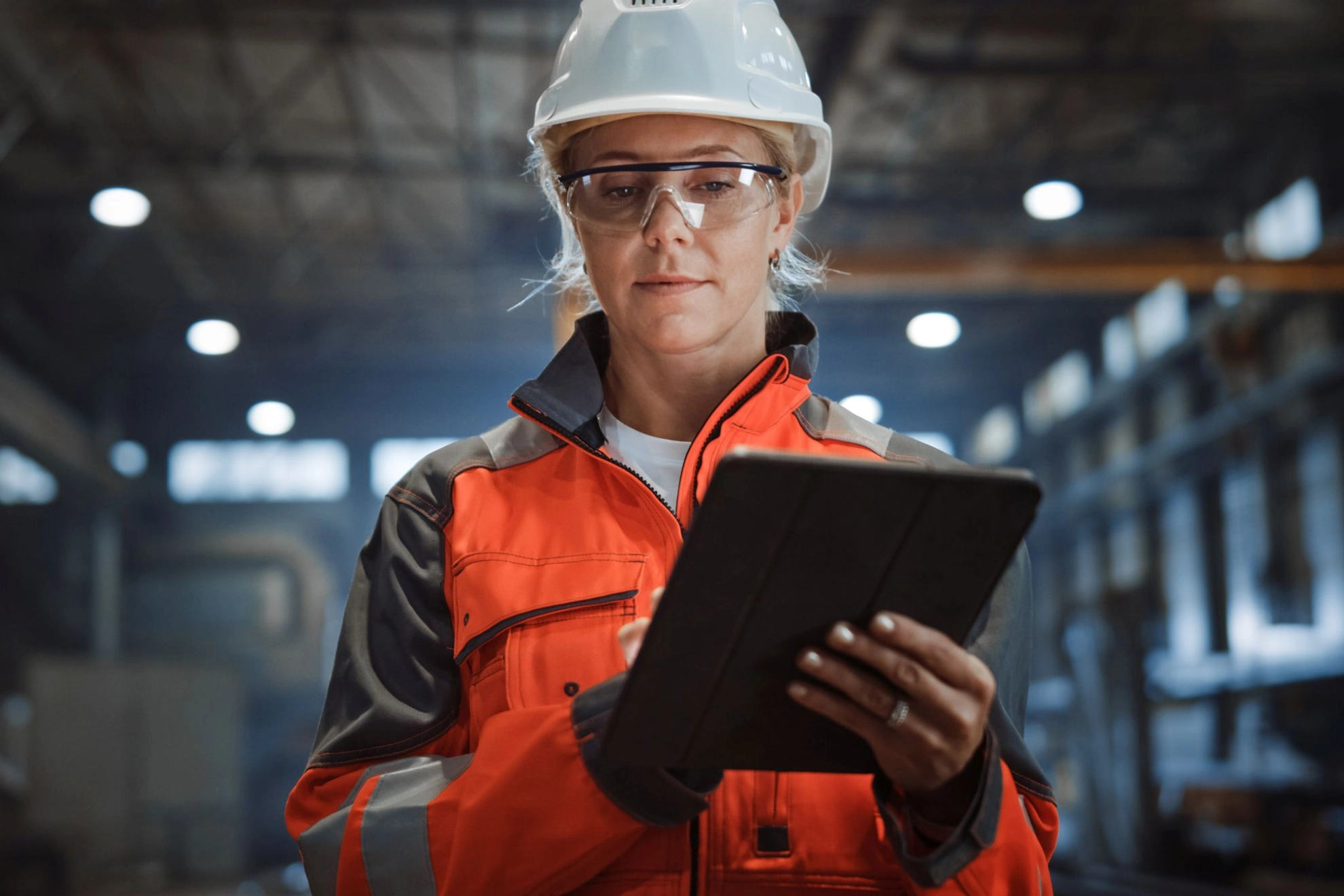 Arbeiterin mit Helm und Tablet