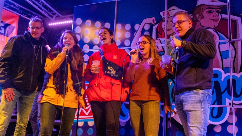 Eine junge Gruppe Menschen singt auf der Bühne